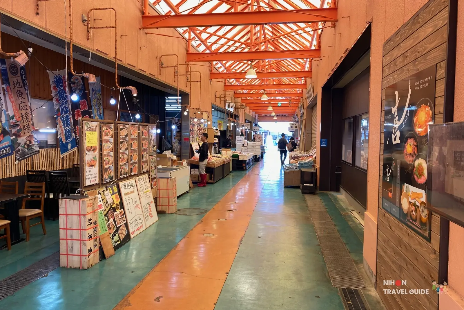 Covered indoor hallway at Nakaminato Fish Market lined with seafood restaurants, menu boards, and shops, showing the vibrant market interior in Ibaraki