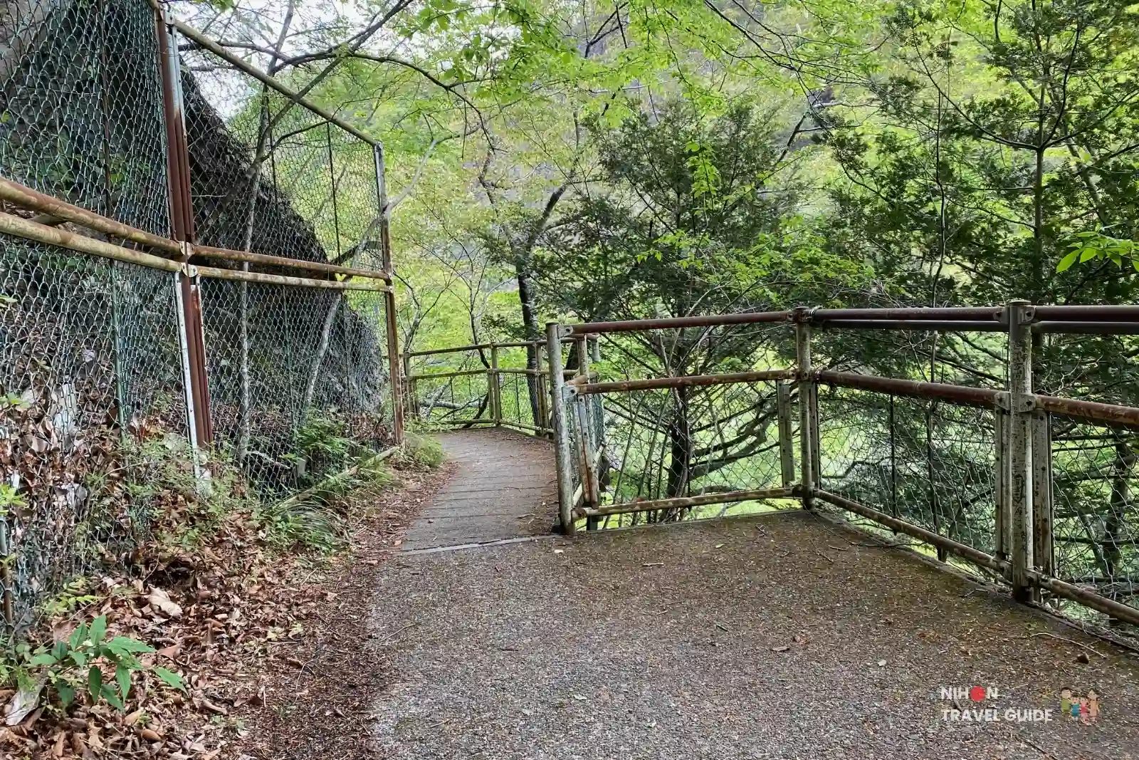 Observation deck and walkway overlooking Namase Falls, with metal railings and forested surroundings