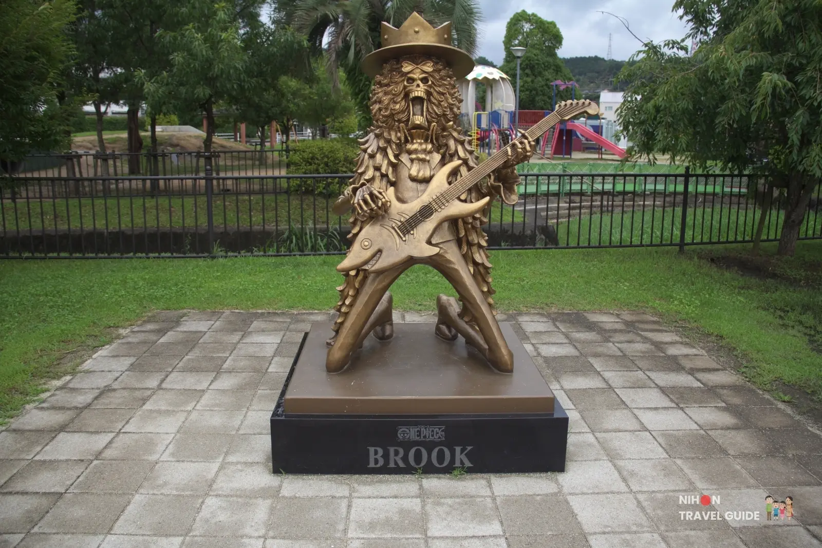 Full front view of the bronze Brook statue from One Piece holding a guitar at Mifune Fureai Park Dinosaur Park in Kumamoto
