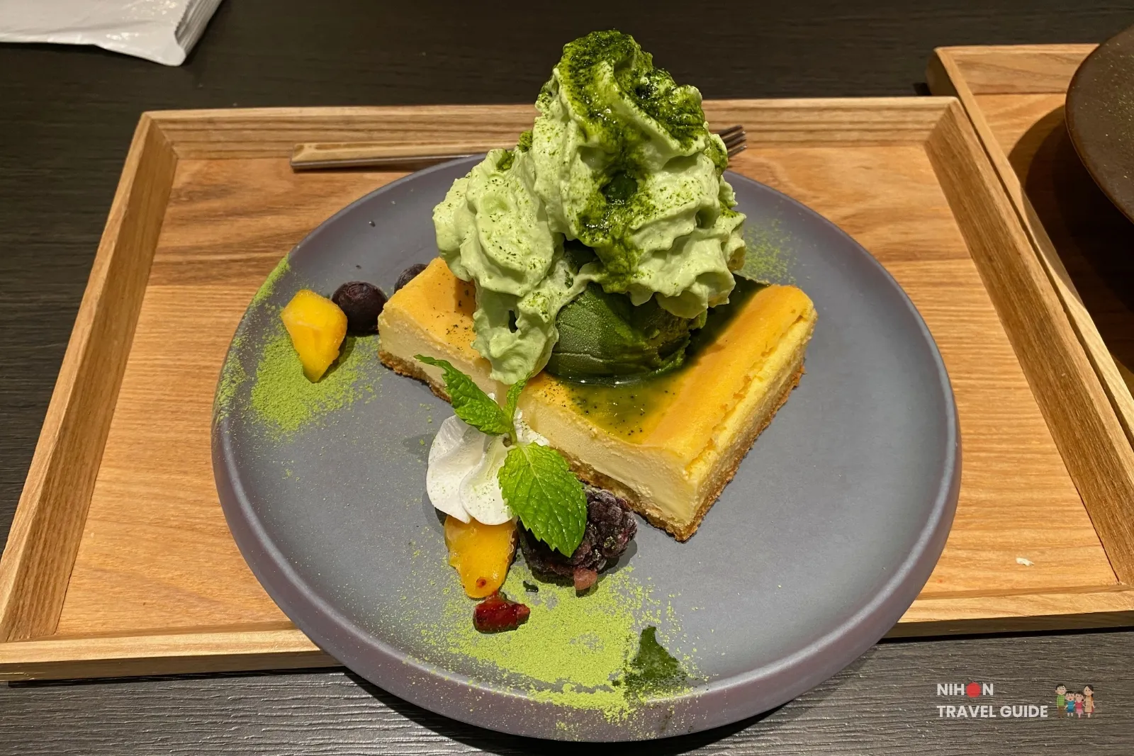 Cheesecake topped with matcha soft serve, berries, and matcha powder at CHASEN Cafe in Sakura Machi Kumamoto.