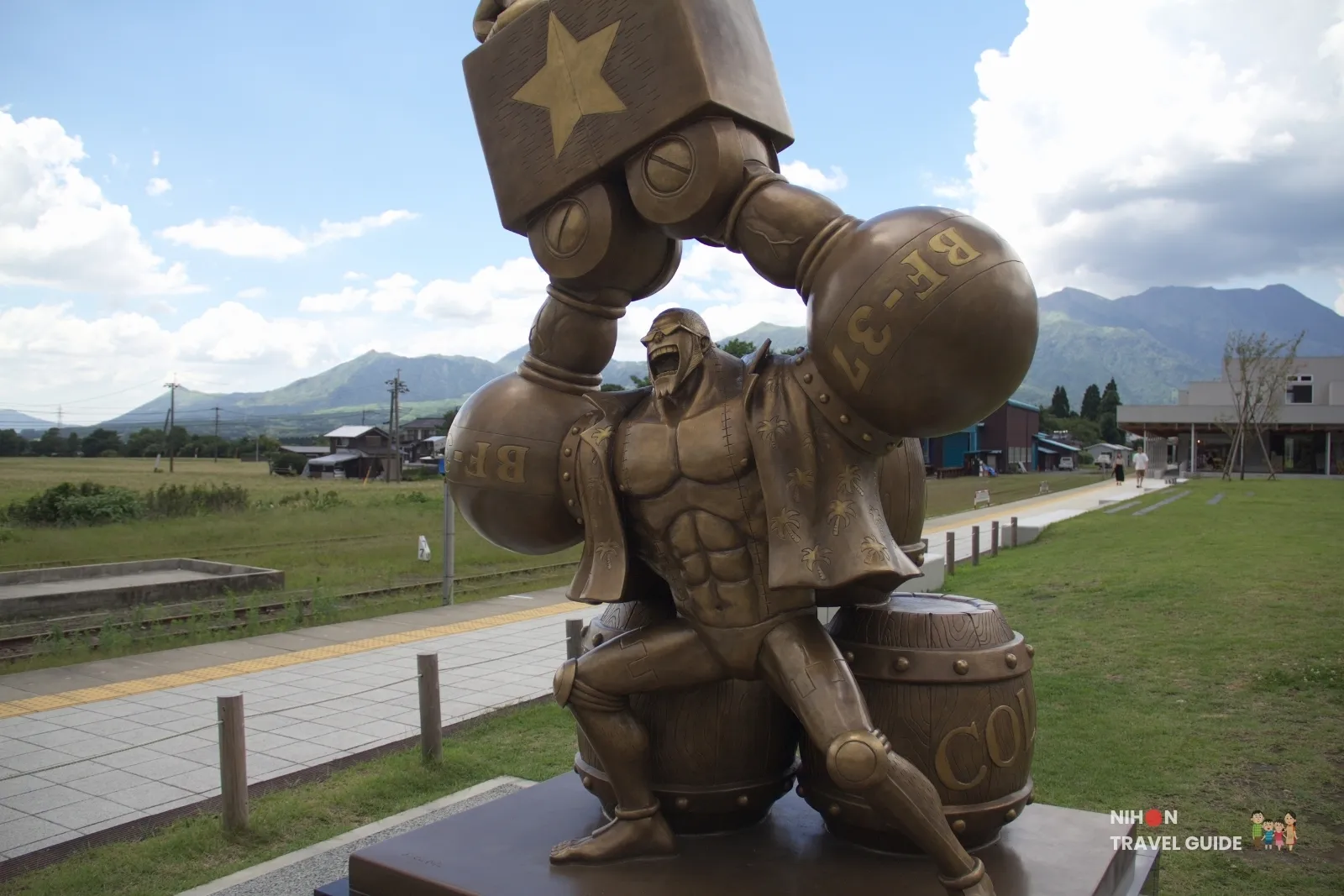 Close-up of the bronze Franky statue from One Piece with his large robotic arms at Takamori Station in Kumamoto.