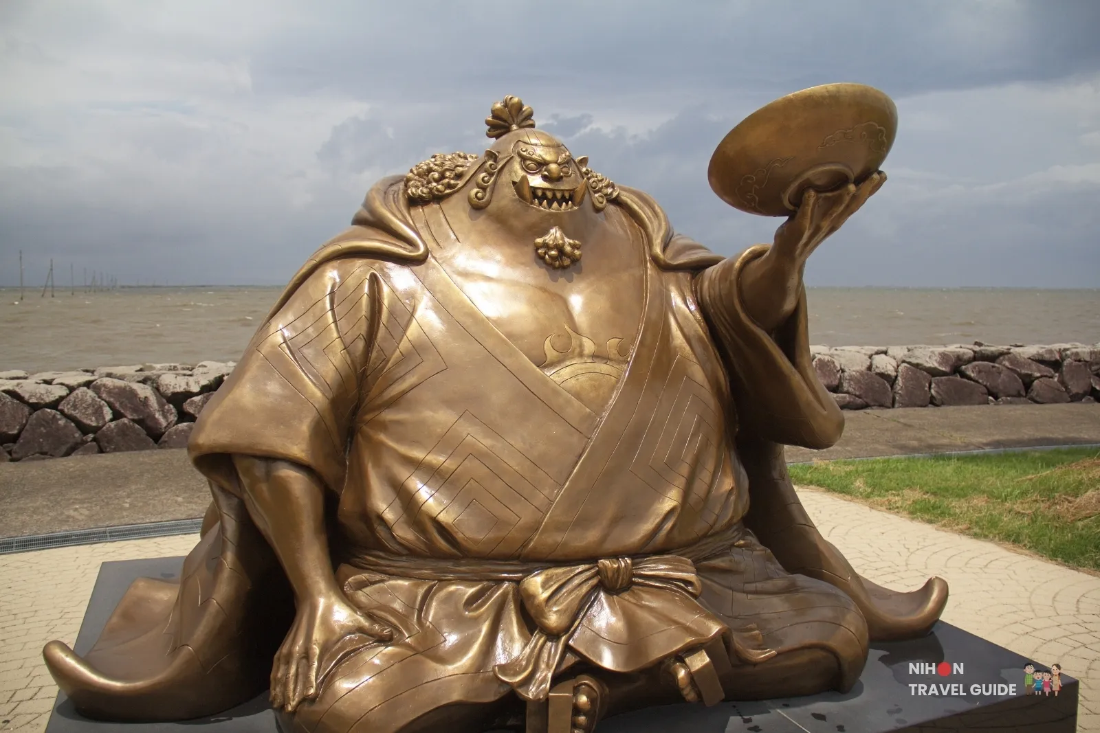 Side view of the bronze Jinbe statue from One Piece raising a bowl at Sumiyoshi Seaside Park overlooking the Ariake Sea in Kumamoto