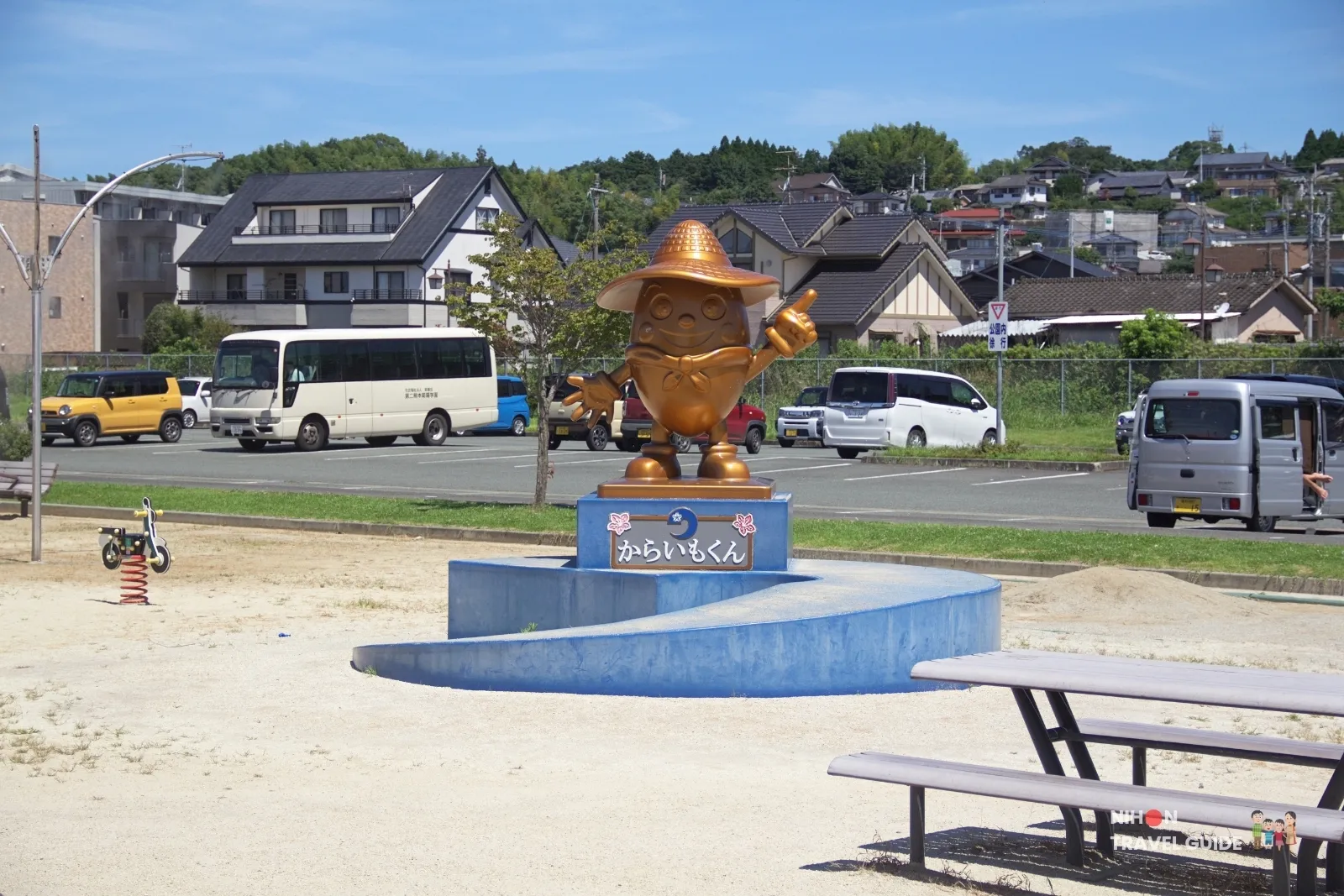 Golden Karaimo-kun sweet potato mascot statue at Ozu Central Park near the Zoro One Piece statue in Kumamoto.