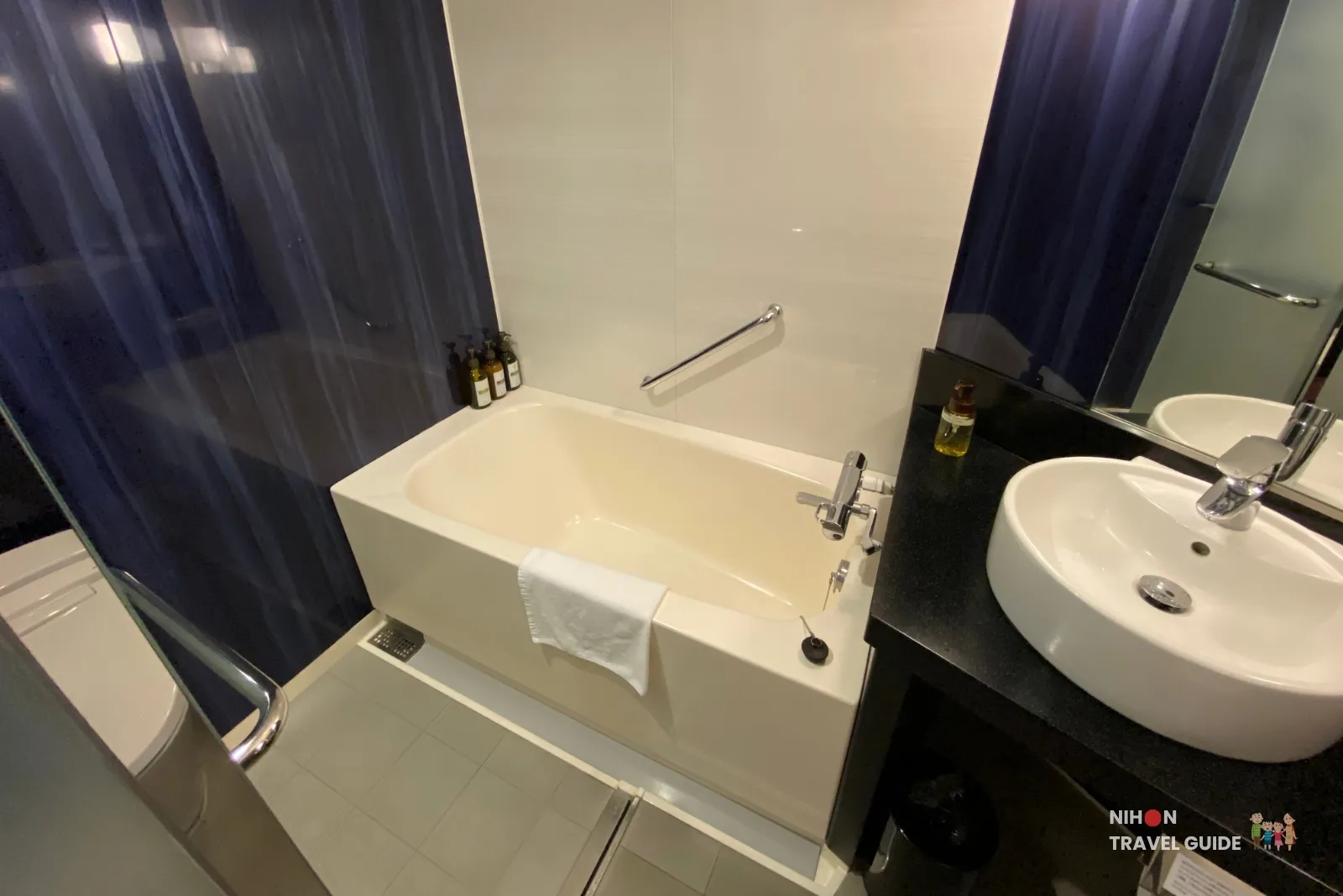 Bathroom at KOKO HOTEL Premier Kumamoto featuring a deep bathtub, vessel sink, and toiletries.