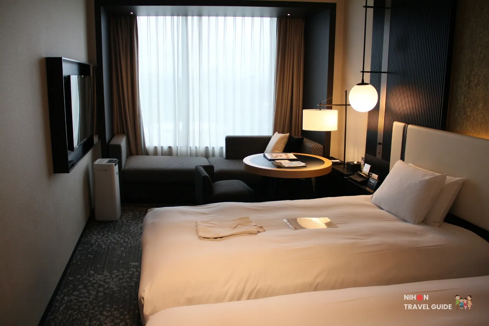 Superior Twin room at KOKO HOTEL Premier Kumamoto, featuring two beds, a sofa seating area by the window, wall-mounted TV, and modern contemporary design.