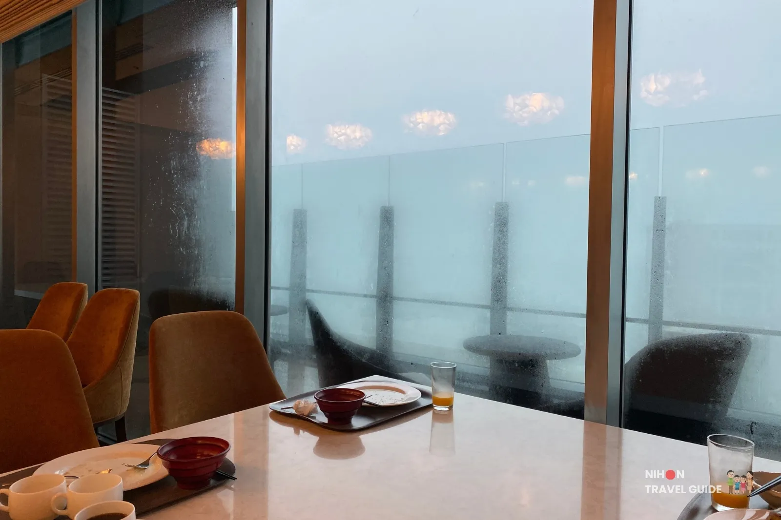 koko-hotel-premier-kumamoto-the-moment-rainy-view Rainy day view from THE MOMENT restaurant at KOKO HOTEL Premier Kumamoto, looking out through misted windows over the outdoor terrace.