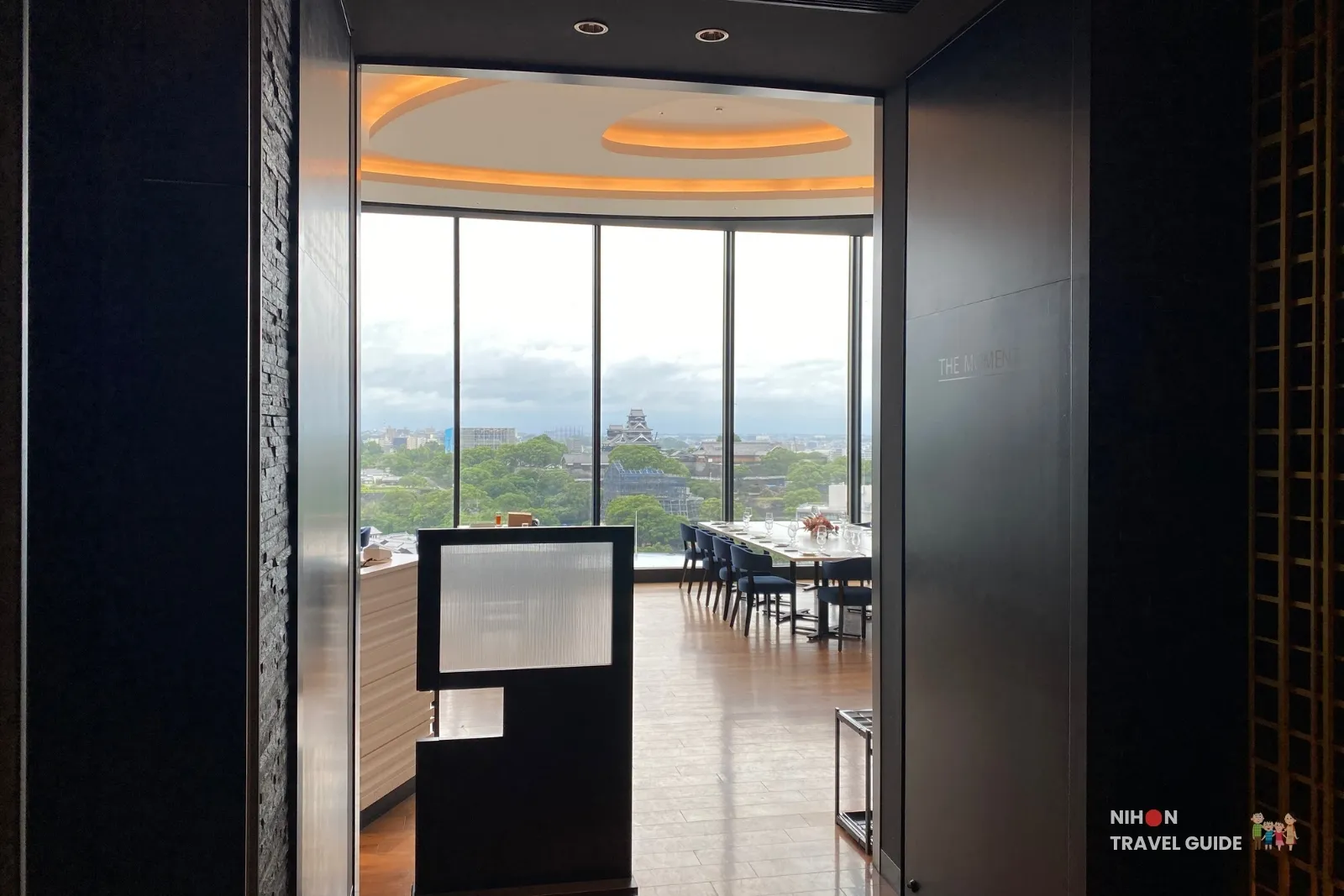 Entrance to THE MOMENT restaurant at KOKO HOTEL Premier Kumamoto, offering panoramic views of Kumamoto Castle through floor-to-ceiling windows.