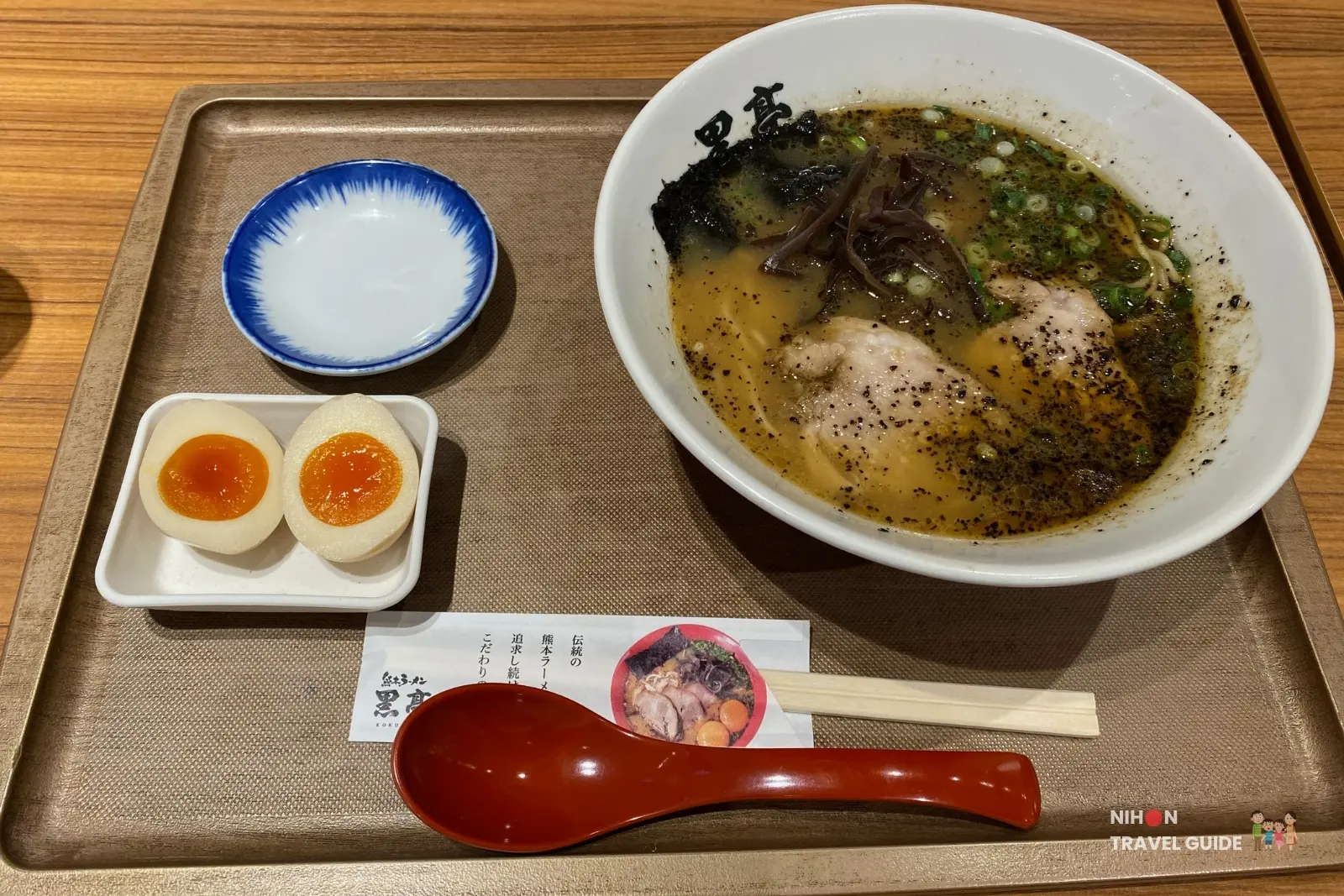 Traditional Kumamoto ramen from Kokutei (黒亭) at Sakura Machi, featuring rich tonkotsu broth with black garlic oil, chashu, nori, green onions, and a soft-boiled egg on the side.