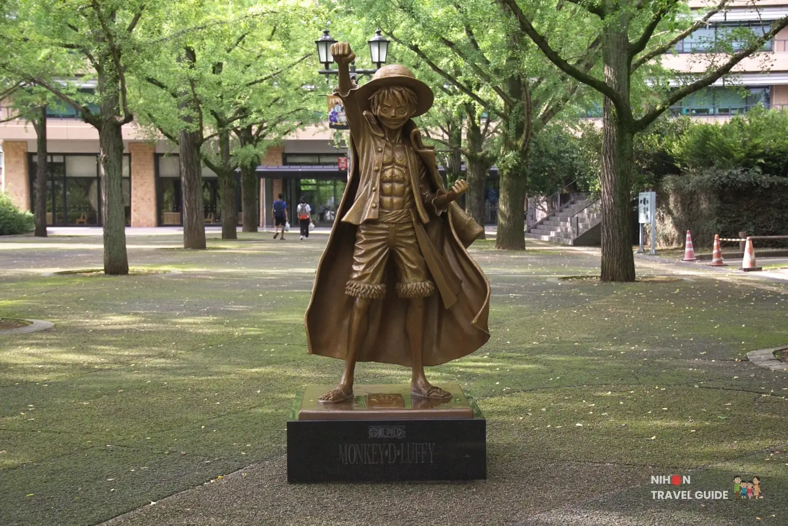 Full front view of the bronze Monkey D. Luffy statue from One Piece standing in front of Kumamoto Prefectural Government Office.