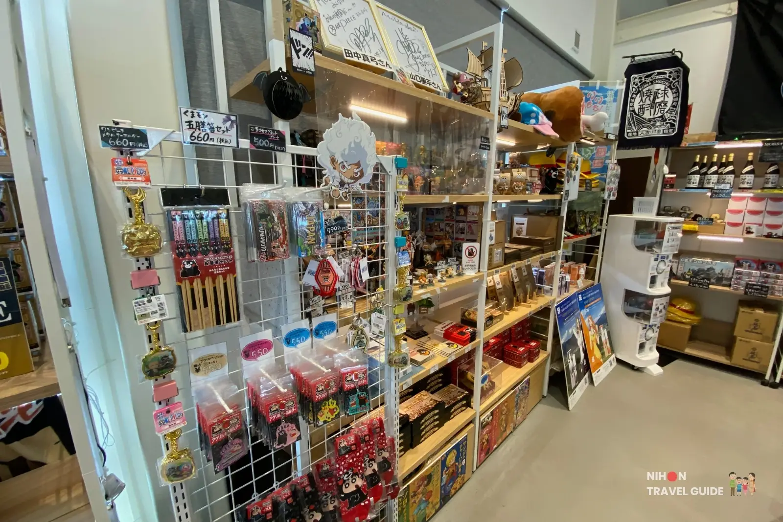 One Piece and Kumamon merchandise display including keychains and goods inside OKAGESAMA MOBA near the Jinbe statue in Kumamoto