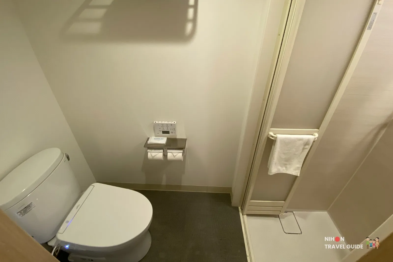 Japanese washlet toilet and entrance to the compact shower booth in the Single Room with Shower Booth at REF Kumamoto by Vessel Hotels