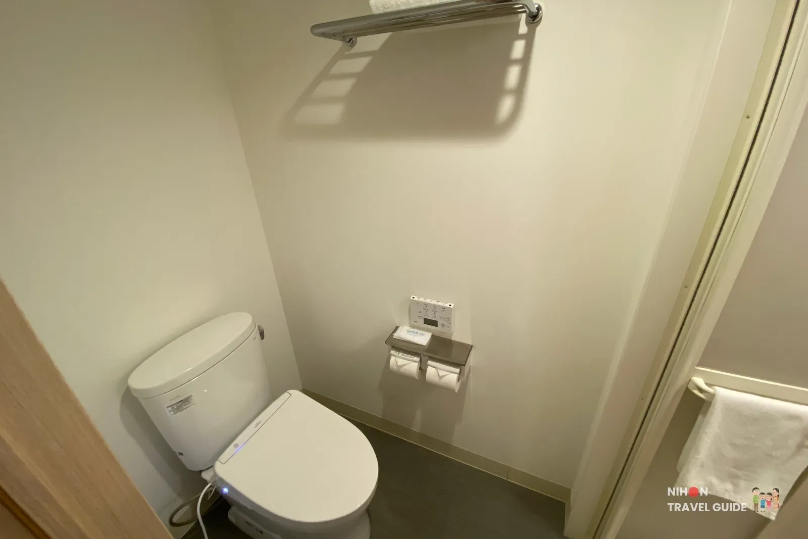 Washlet toilet with control panel and towel rack in the Single Room with Shower Booth at REF Kumamoto by Vessel Hotels