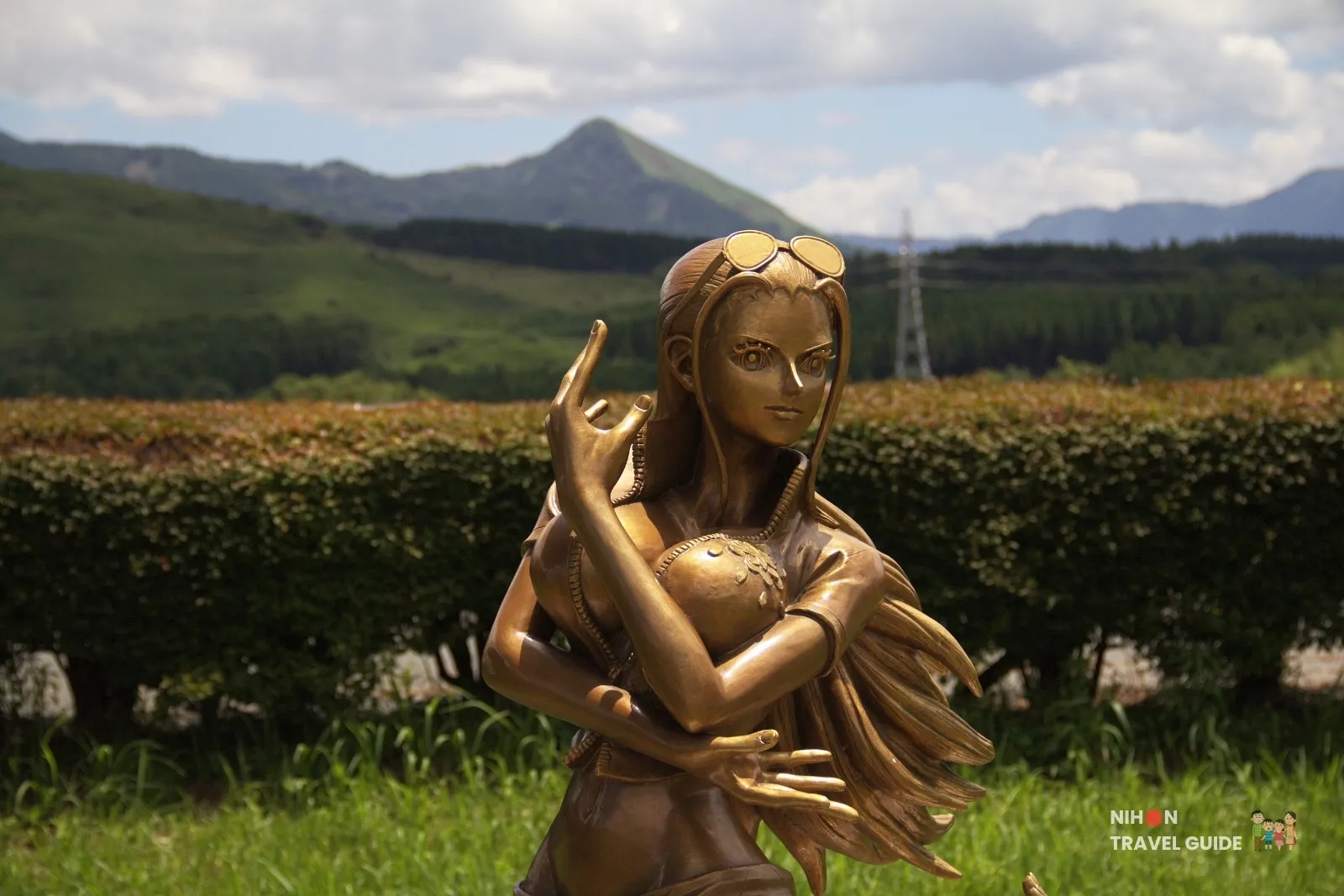 Close-up of the bronze Nico Robin statue from One Piece at Kumamoto Earthquake Memorial Museum KIOKU with mountains behind.
