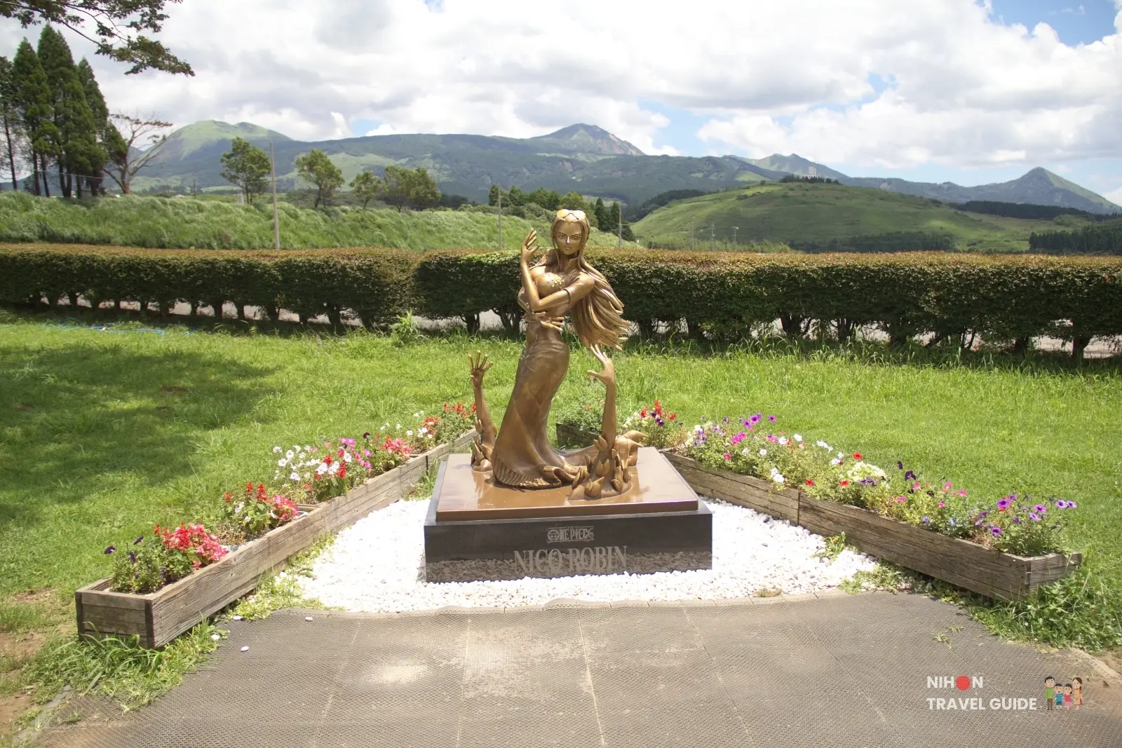 Full front view of the bronze Nico Robin statue from One Piece at Kumamoto Earthquake Memorial Museum KIOKU with Aso mountains in the background.