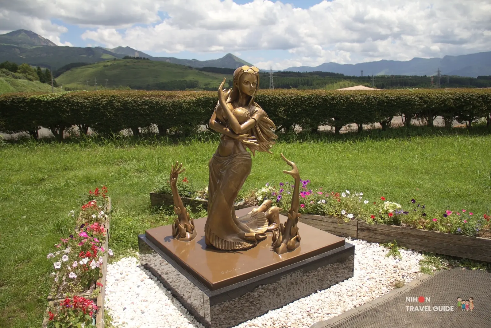 Angled view of the bronze Nico Robin statue from One Piece surrounded by flowers at Kumamoto Earthquake Memorial Museum KIOKU.