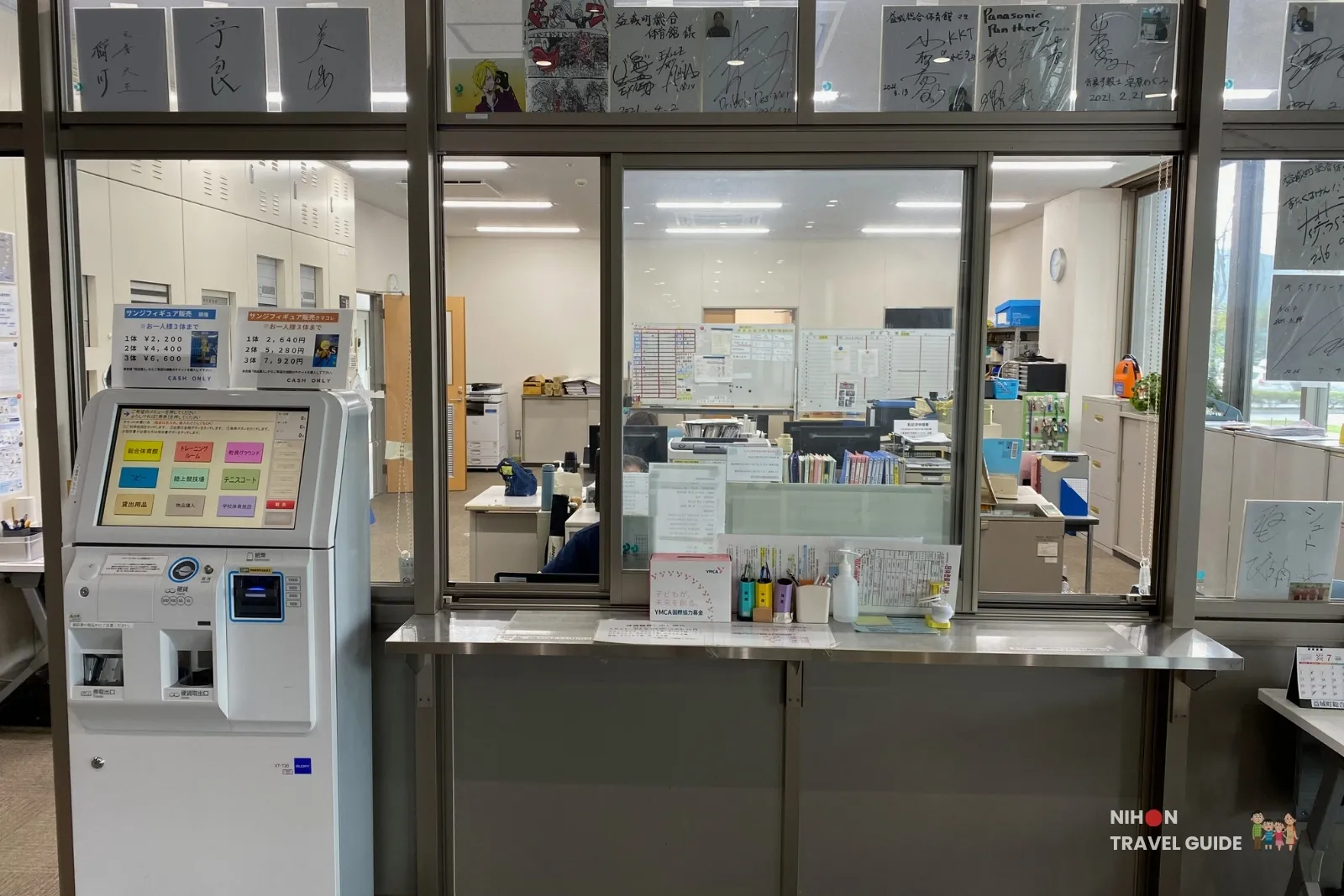 Cash-only ticket machine and office counter for buying limited edition Sanji One Piece figurines inside Mashiki Town General Gymnasium in Kumamoto.