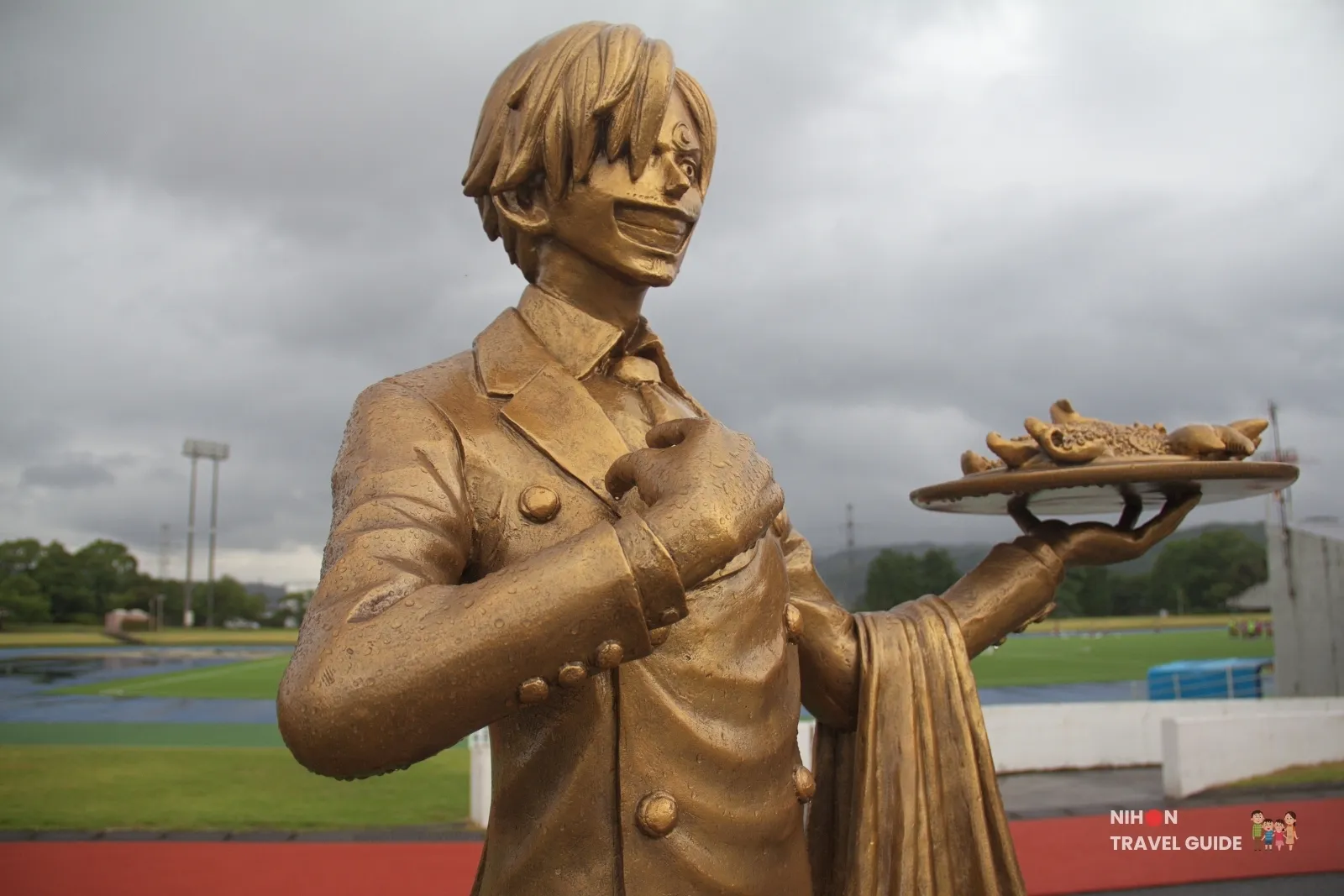 Close-up of the bronze Sanji statue from One Piece holding a tray of food at Mashiki Town Sports Park in Kumamoto.