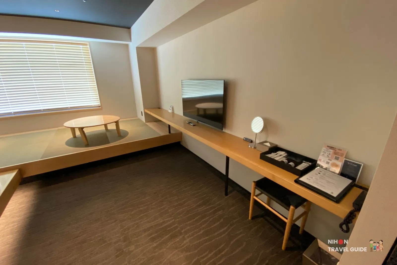 Desk, wall-mounted TV and raised tatami seating area in the Modern Japanese Premium Room at The358 SORA