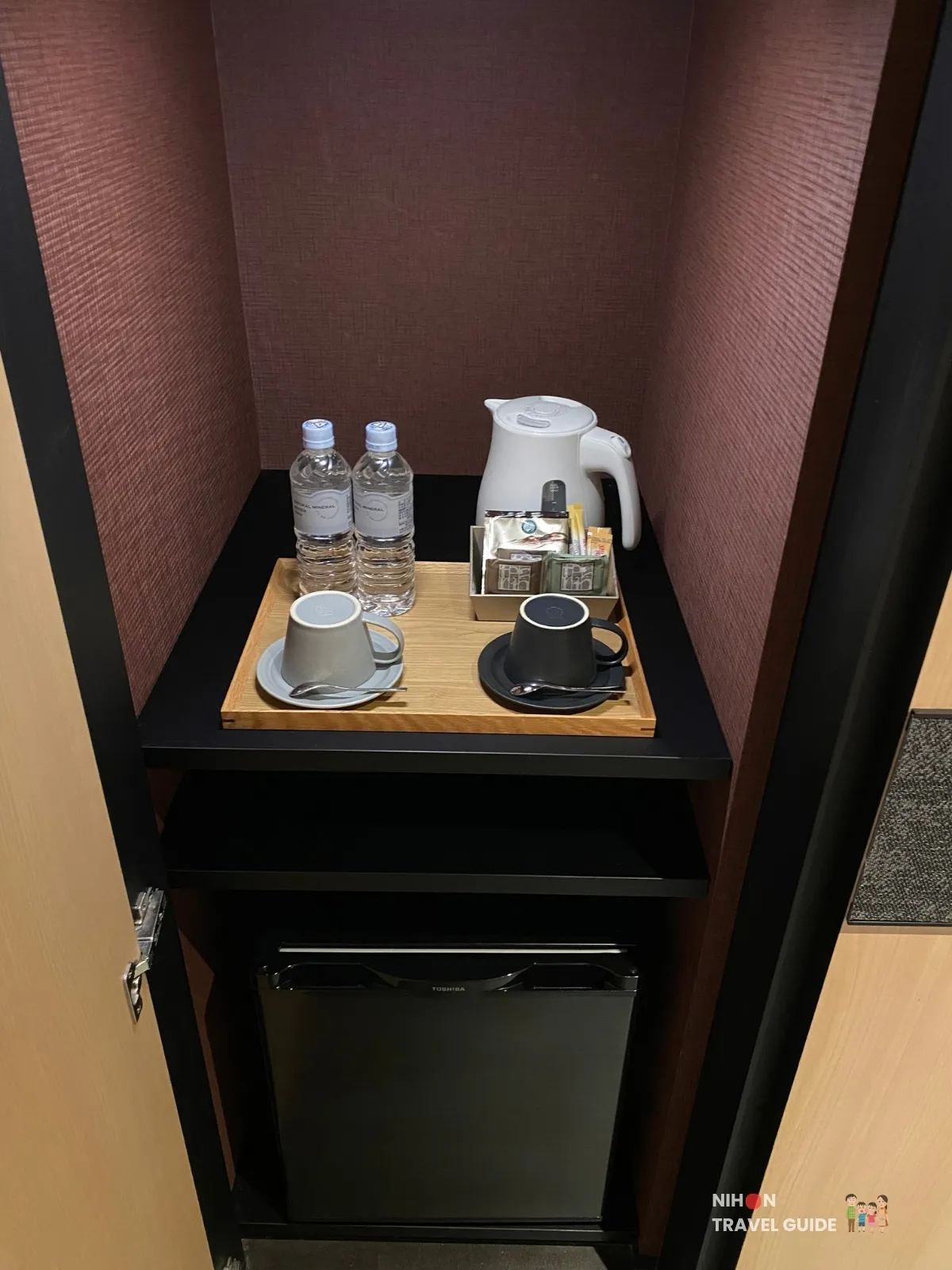 In-room cupboard at The358 SORA with Toshiba fridge, kettle, mineral water and coffee set.