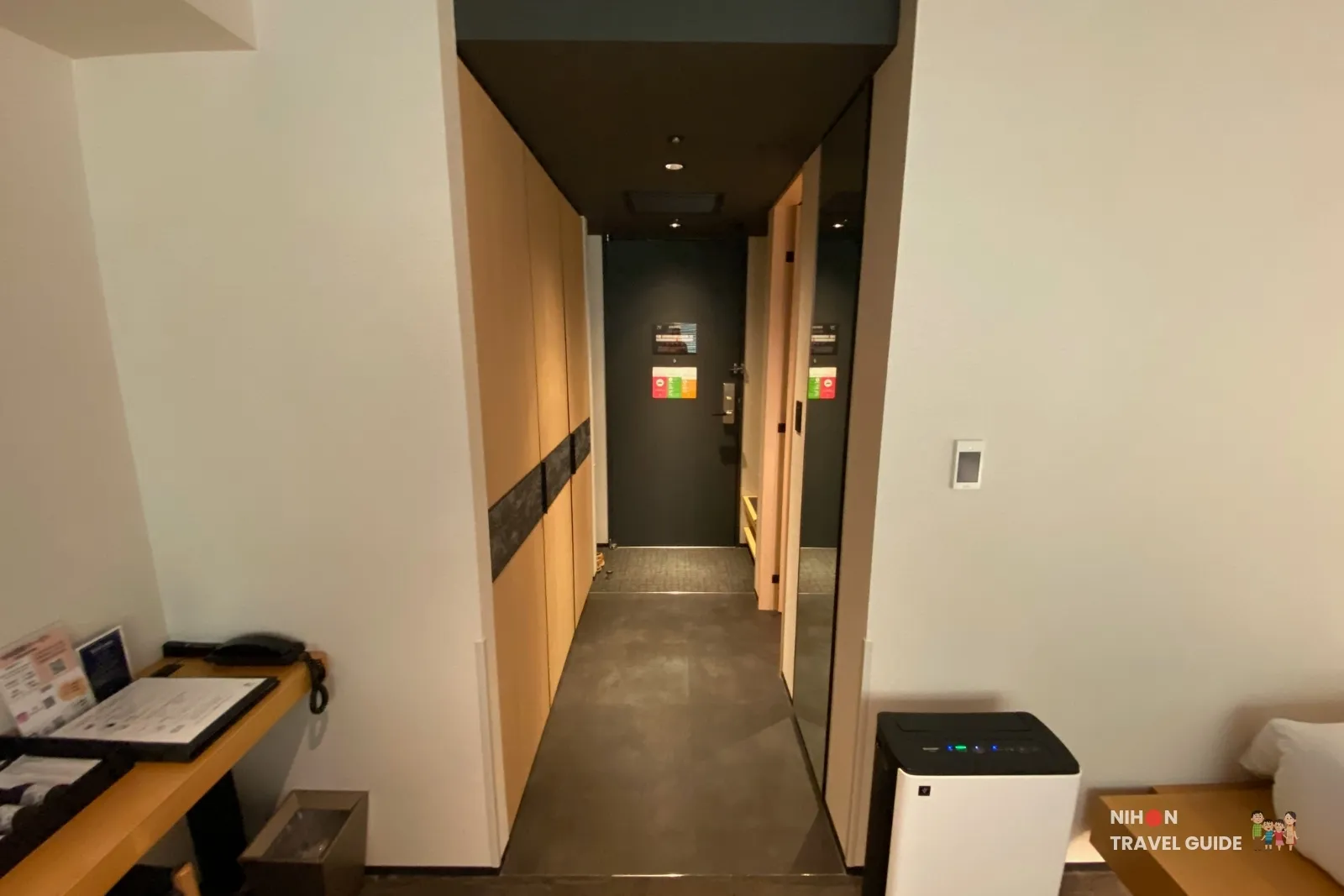 Flush-level hallway from the living area to the door in The358 SORA Modern Japanese Premium Room, with a Sharp air purifier beside the beds.