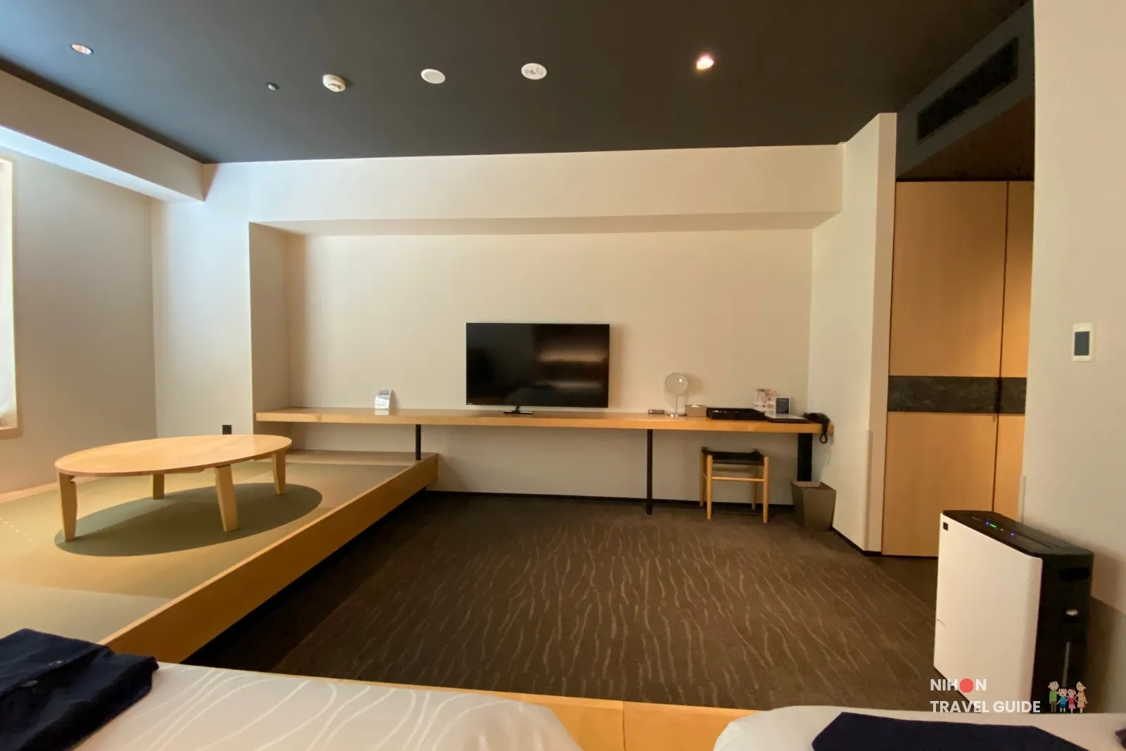 View from the koagari beds toward the TV desk, tatami table and air purifier in The358 SORA Modern Japanese Premium Room.