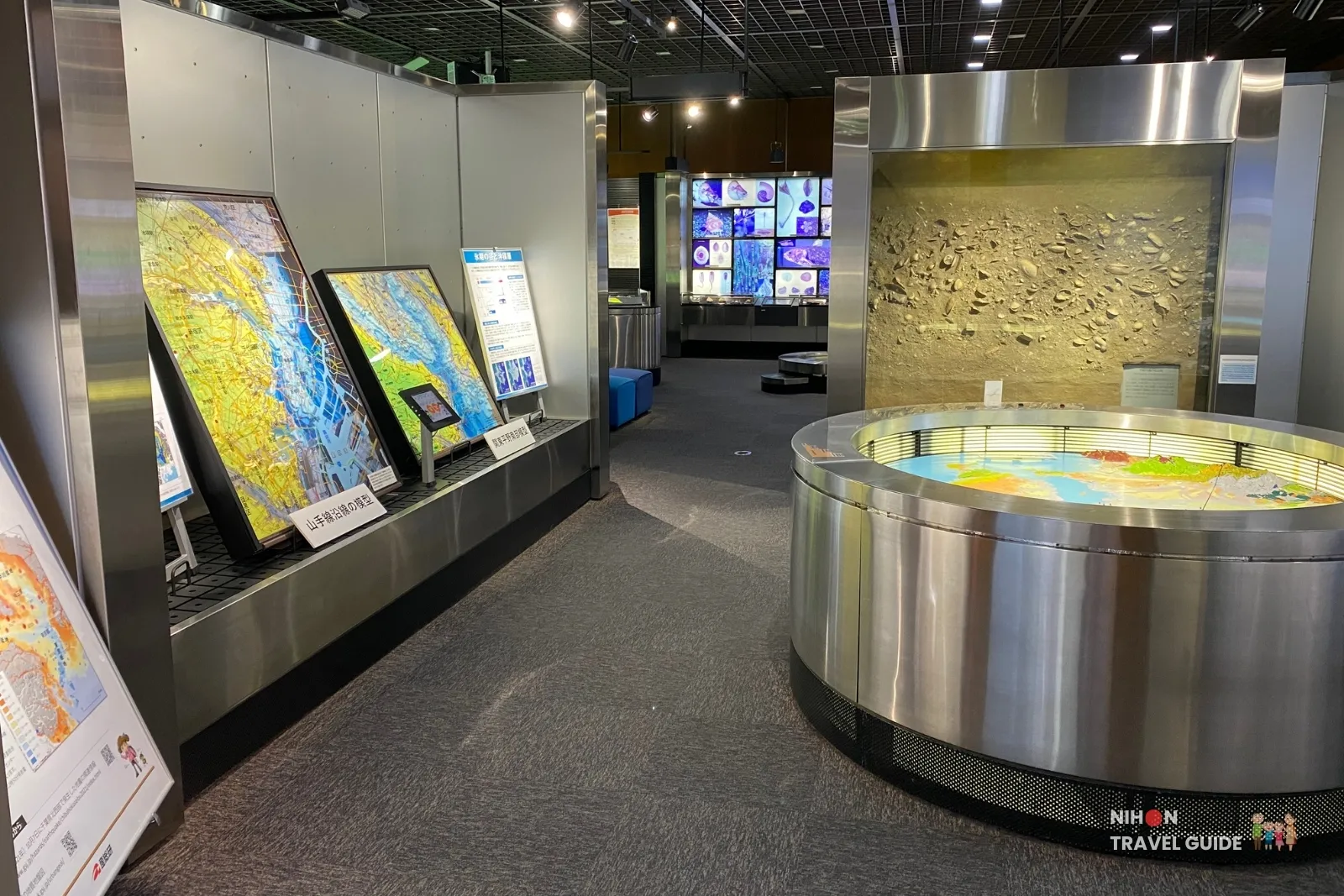 Exhibition Room 1 at the Tsukuba Geological Museum showing large geological maps of Japan and a circular illuminated topographic model of the Kanto region.