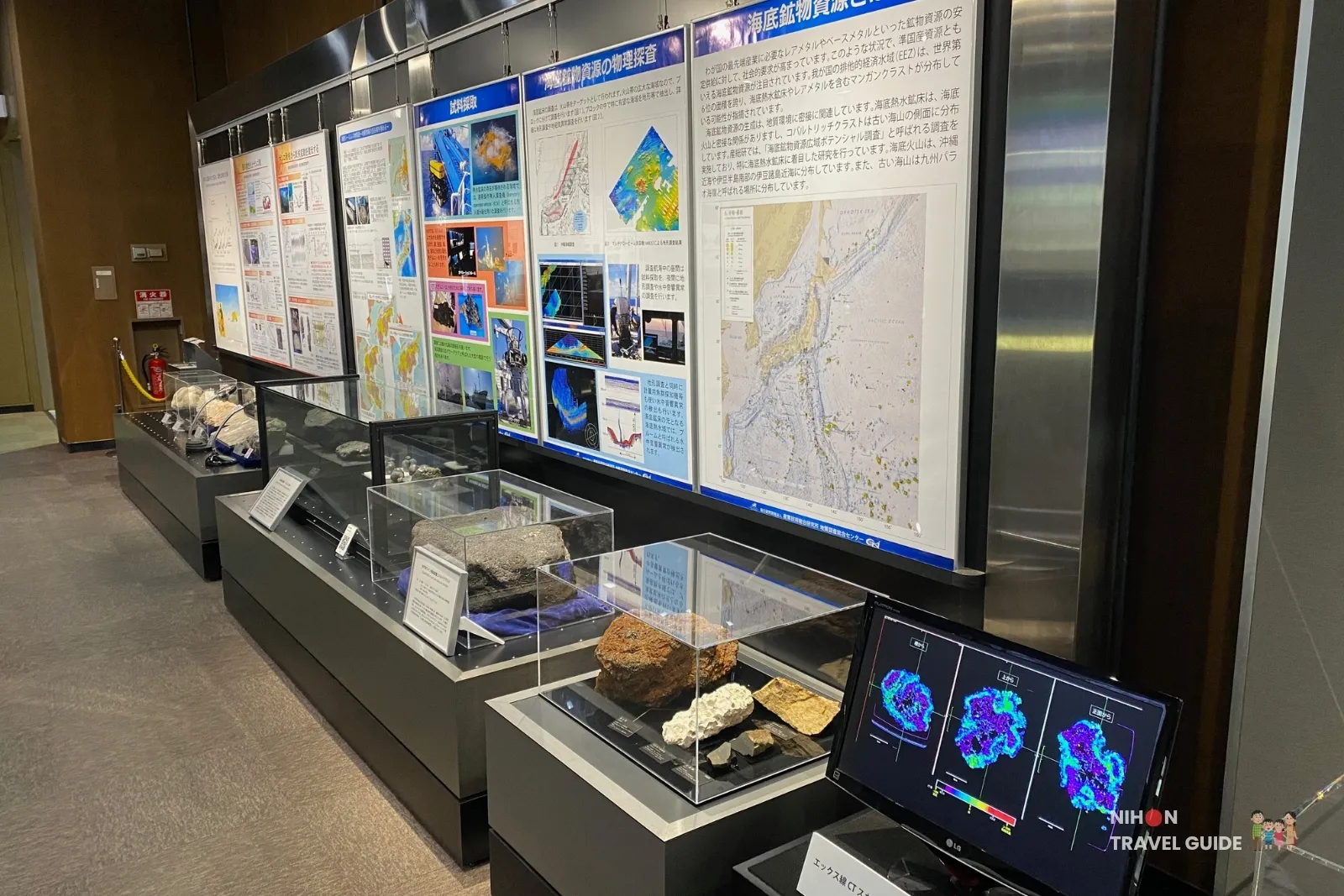 Exhibition panels and rock samples about seafloor mineral resources and exploration methods in Exhibition Room 2 at the Tsukuba Geological Museum, including a monitor showing CT scan images of samples.