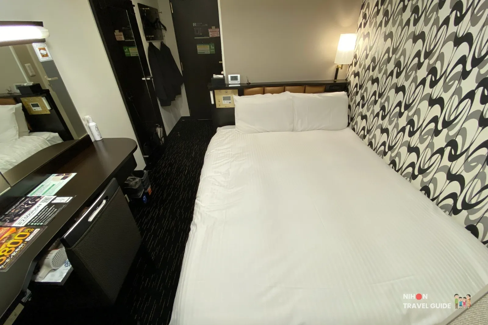 Central standard room at APA Hotel Hakata Eki Chikushiguchi with a 140 cm Cloud Fit bed, patterned headboard wall, and desk with fridge.