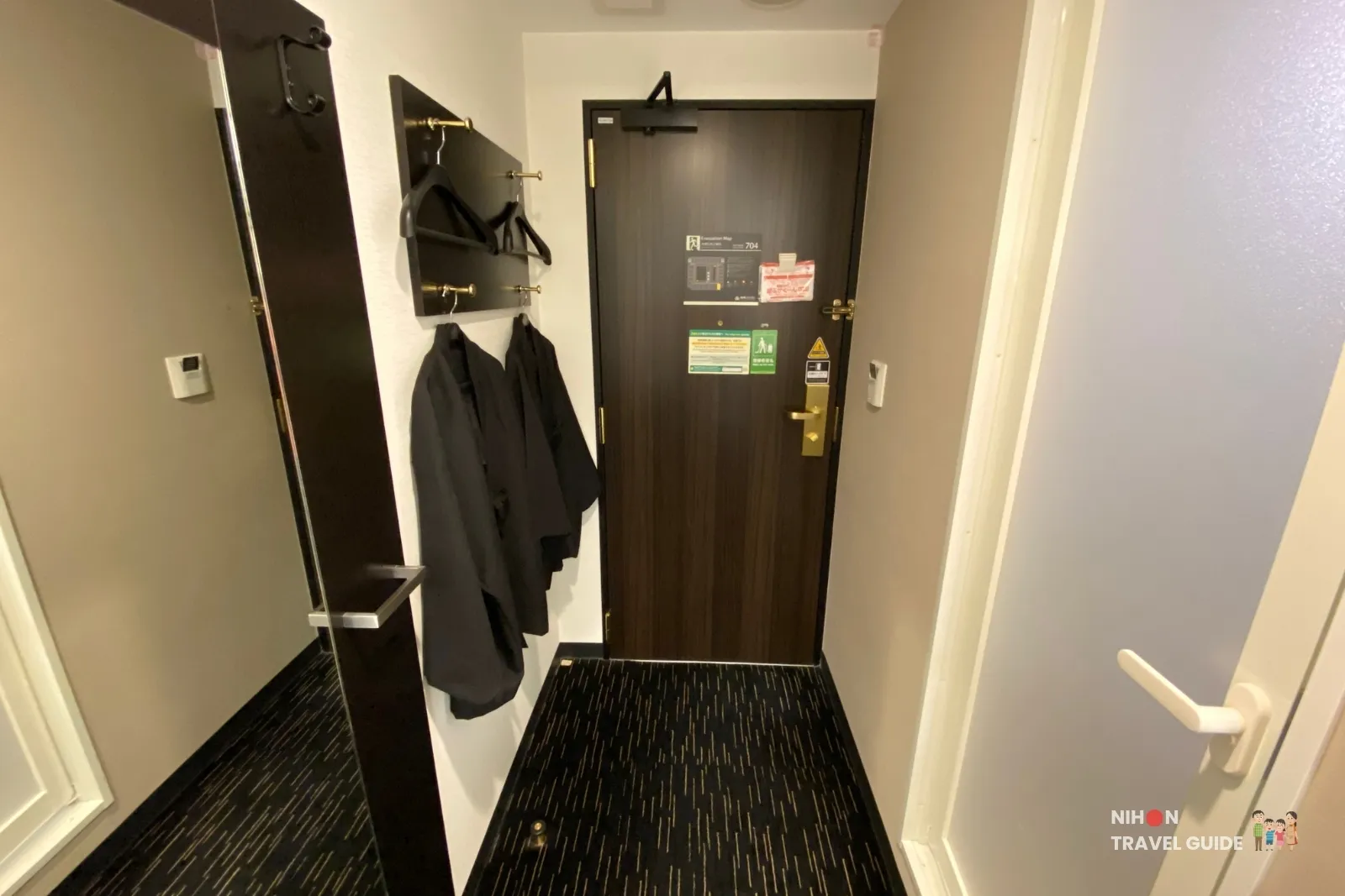 Entrance of a standard room at APA Hotel Hakata Eki Chikushiguchi, with the room door, coat hooks, hanging yukata, and a full-length mirror.