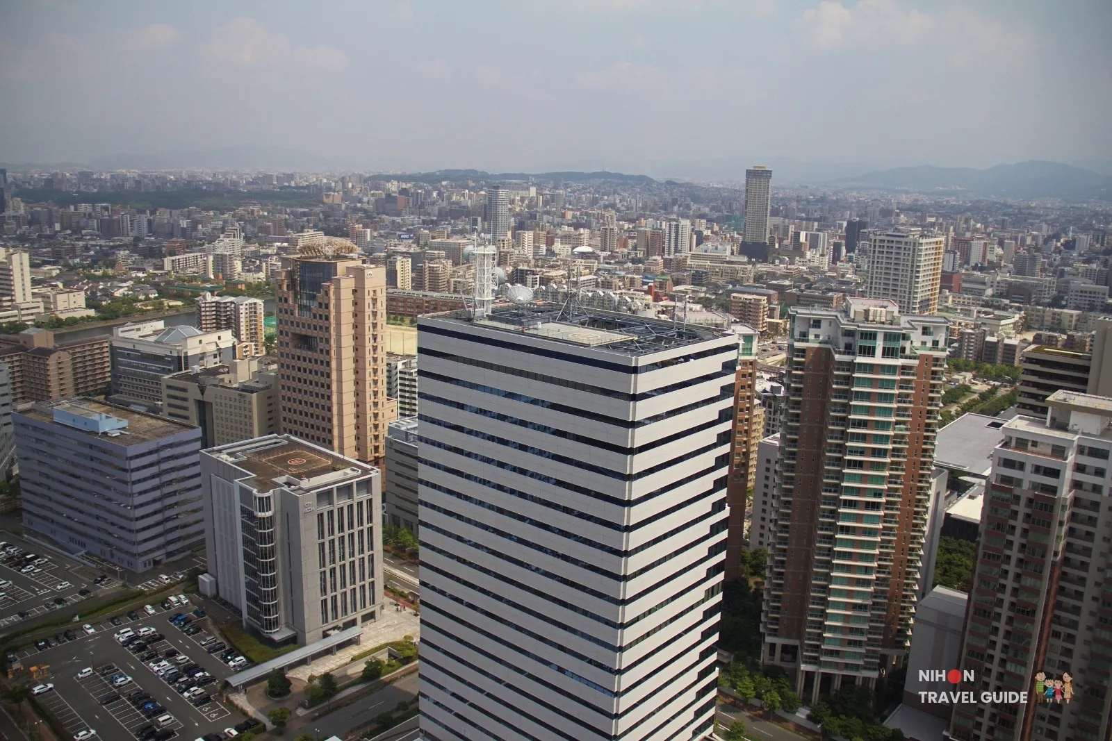 View from Fukuoka Tower over Seaside Momochi office towers and apartments, looking inland toward central Fukuoka and the hills.